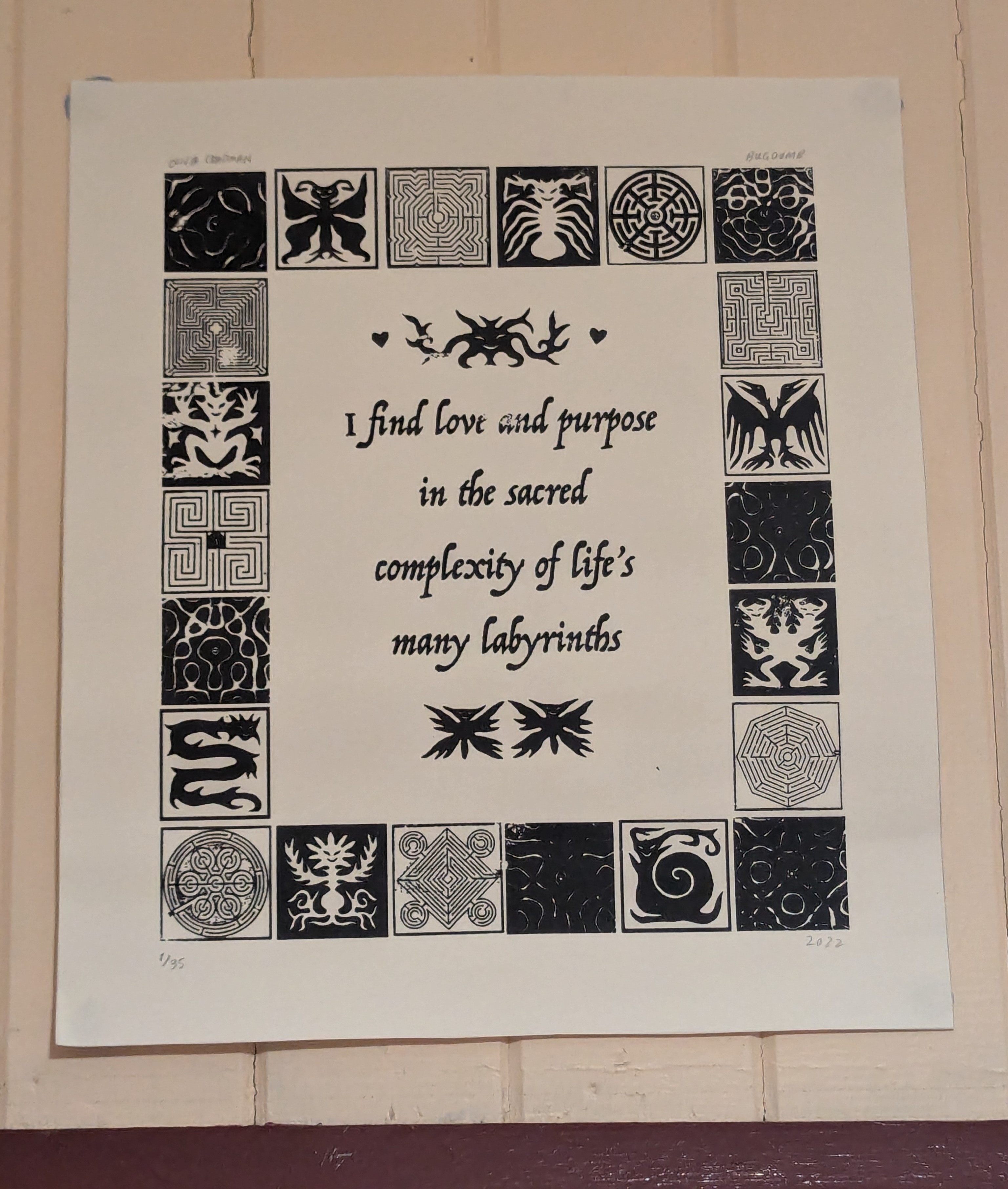 A lino-cut print on Julian's wall which reads "I find love and purpose in the sacred complexity of life's many labyrinths."